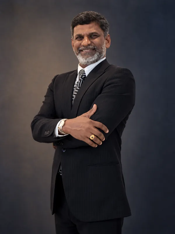 Studio portrait of Prof. Sivarao Subramonian smiling with his arms crossed